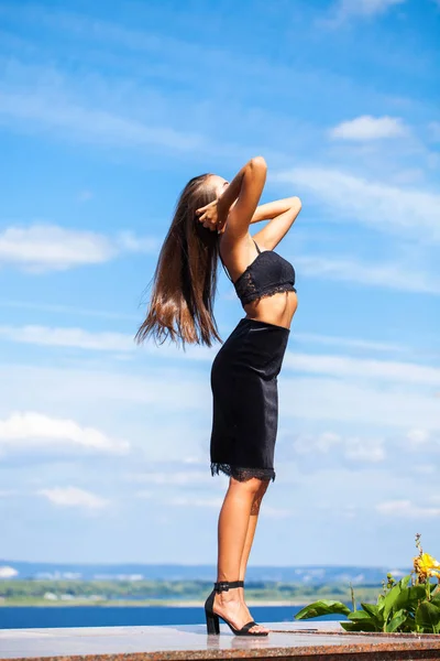 Portrait of a young beautiful girl in a black skirt and a bra po — Stock Photo, Image