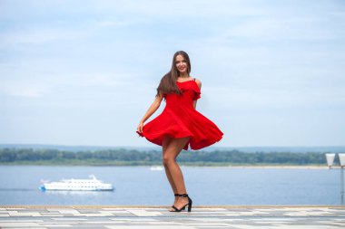 Seksi kırmızı elbiseli güzel esmer manken.