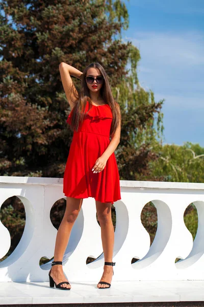 Hermosa modelo morena en vestido rojo sexy — Foto de Stock