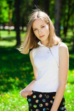 Yaz parkında genç ve güzel bir esmer kızın portresi.