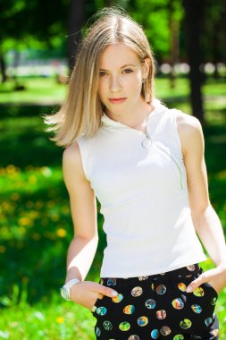 Yaz parkında genç ve güzel bir esmer kızın portresi.