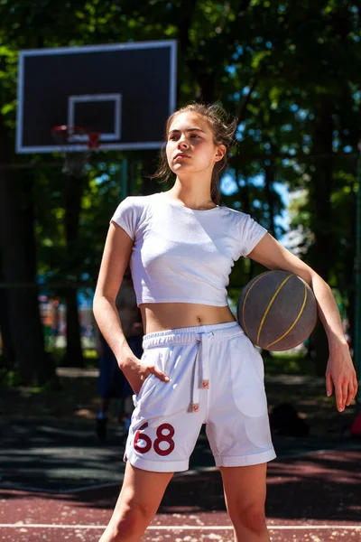 在操场上摆着篮球的年轻漂亮的姑娘 — 图库照片