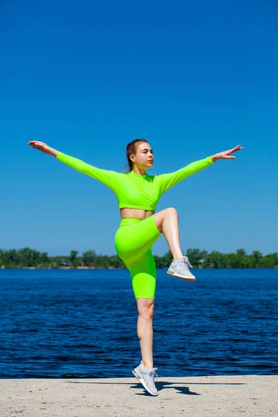 一位年轻女运动员的全身像在伏尔加河畔进行体育锻炼 — 图库照片