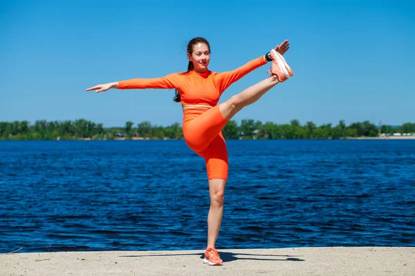 一位年轻女运动员的全身像在伏尔加河畔进行体育锻炼 — 图库照片