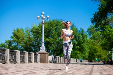 Genç ve güzel bir kız sıcak yazda gezinti güvertesinde koşuyor.