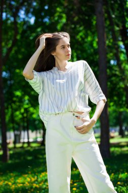 Yaz parkında genç ve güzel bir esmer kızın portresi.