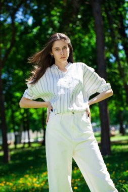 Yaz parkında genç ve güzel bir esmer kızın portresi.