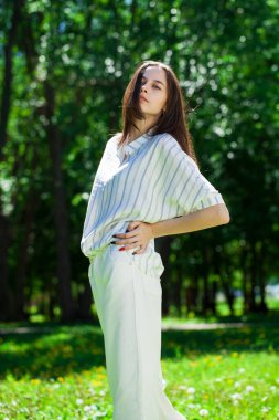 Yaz parkında genç ve güzel bir esmer kızın portresi.