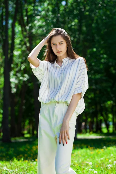 Yaz parkında genç ve güzel bir esmer kızın portresi.