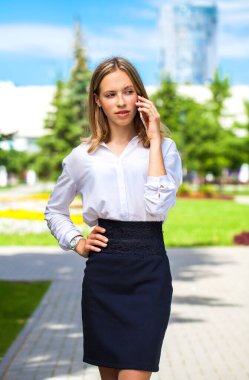 Beyaz bluzlu genç bir asistanın portresi. Sokaktan arıyor.