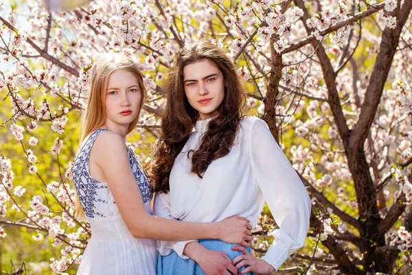 Δύο Χαρούμενα Κορίτσια Ποζάρουν Στον Κήπο Κοντά Στην Ανθισμένη Κερασιά — Φωτογραφία Αρχείου