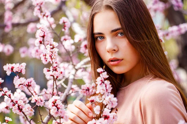 漂亮的少女躺在白花樱桃树旁的花园里 春天的时间 — 图库照片