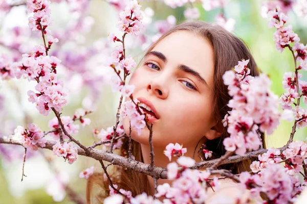 漂亮的少女躺在白花樱桃树旁的花园里 春天的时间 — 图库照片
