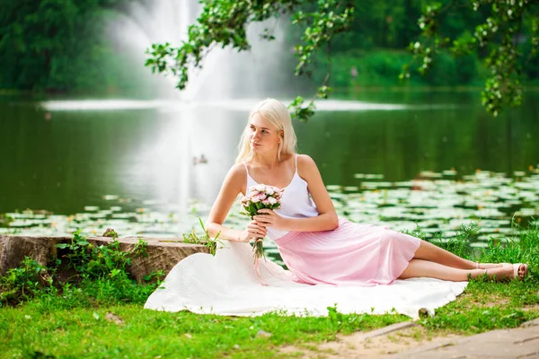 夏园池塘边躺着的一位年轻女子的全长画像 — 图库照片