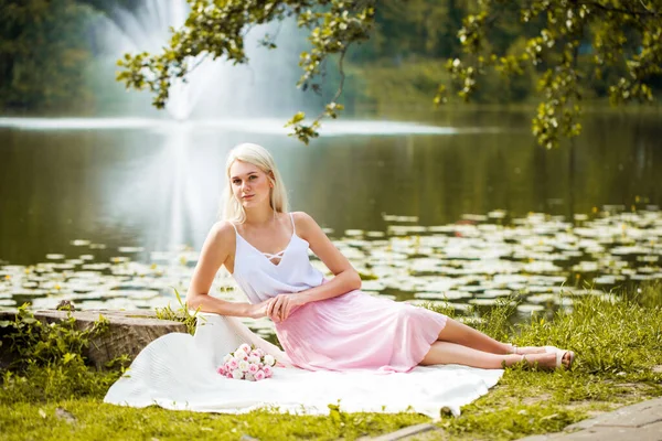 夏の公園の池の近くに眠る若い女性の全長の肖像画 — ストック写真