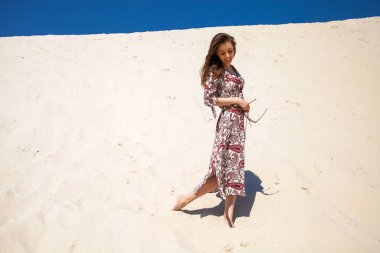 Uzun elbiseli güzel sarışın bir kızın vücut portresi.