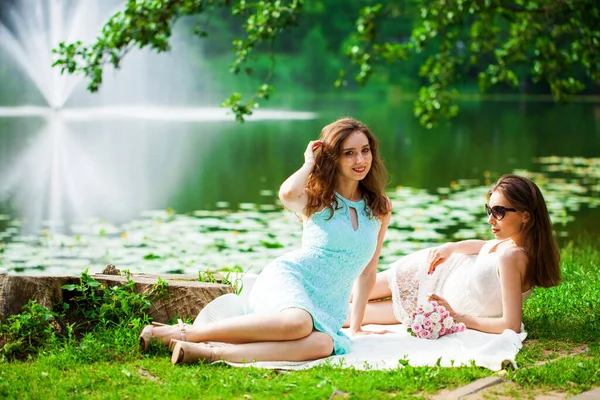 一个年轻女子躺在夏季公园池塘边的全长肖像 — 图库照片