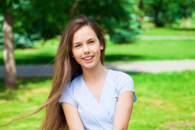 Yaz parkında genç ve güzel bir esmer kızın portresi.