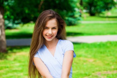 Yaz parkında genç ve güzel bir esmer kızın portresi.