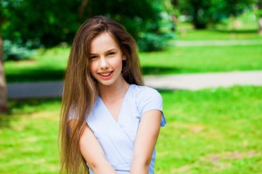 Yaz parkında genç ve güzel bir esmer kızın portresi.