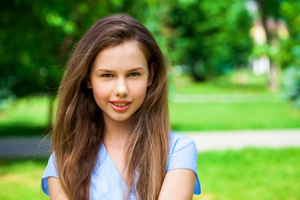 一个身穿蓝色衣服的年轻漂亮的黑发女孩在夏季公园摆姿势的画像 — 图库照片