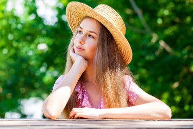 Hasır şapkalı genç bir kızın portresi.