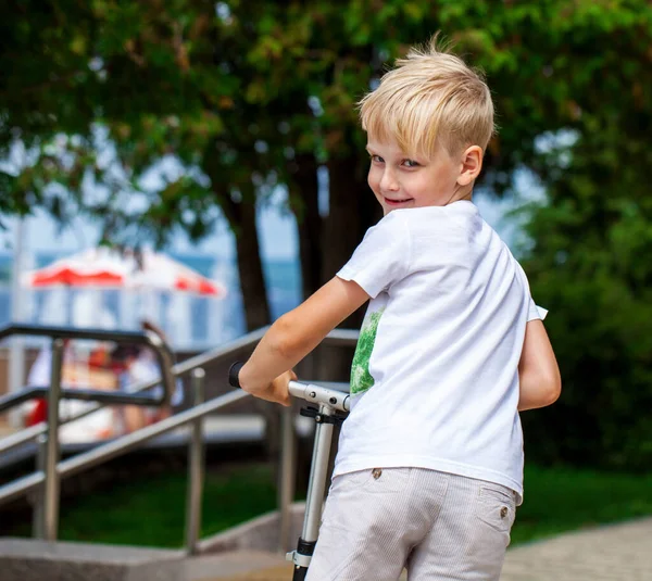 Liten Pojke Ridning Skoter Stadsparken — Stockfoto