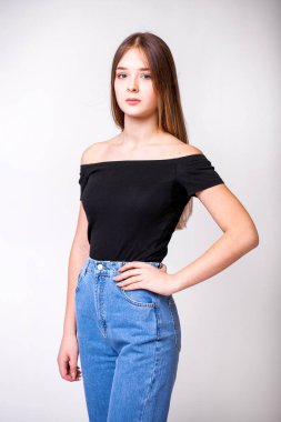 Gri arka planda izole edilmiş mavi kotlu güzel bir kızın yakın plan portresi.