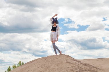 Tasarımcı kıyafetleriyle kuş tüyü peruklu manken portresi.