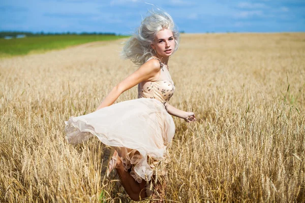 一个穿着时髦服装的金发年轻女子走遍麦田的全身像 — 图库照片
