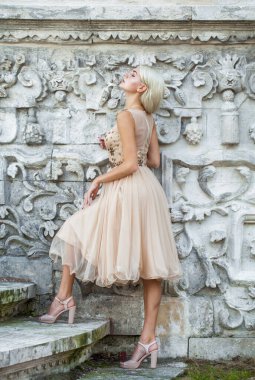 Bej elbiseli güzel sarışın bir kadının vücut portresi.