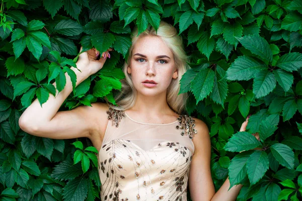 Sarmaşık içinde, açık havada, yaz parkında genç ve güzel bir kadının portresi.