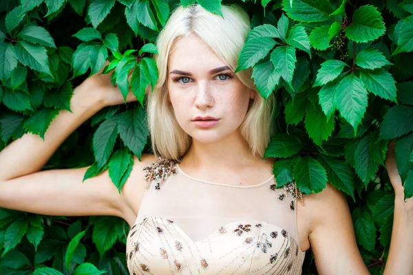 Sarmaşık içinde, açık havada, yaz parkında genç ve güzel bir kadının portresi.