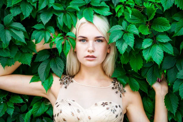 Sarmaşık içinde, açık havada, yaz parkında genç ve güzel bir kadının portresi.