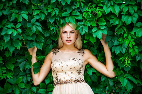Sarmaşık içinde, açık havada, yaz parkında genç ve güzel bir kadının portresi.