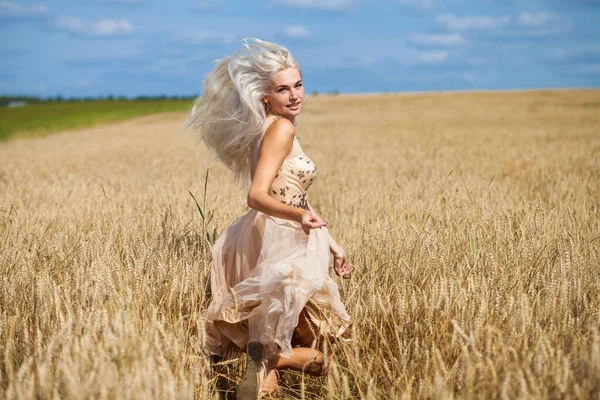 フルボディポートレートの若いです美しいですブロンド女性でファッションドレス歩く小麦畑 — ストック写真