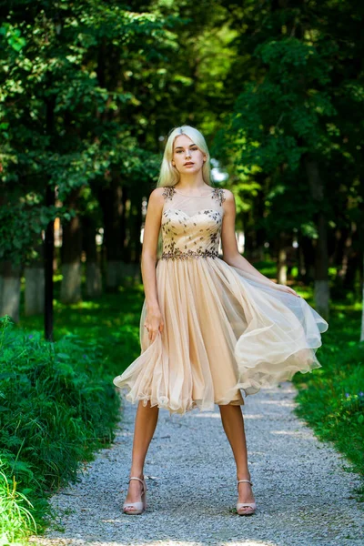 一个身穿米色衣服的金发年轻女子的全身像 露天夏季公园 — 图库照片
