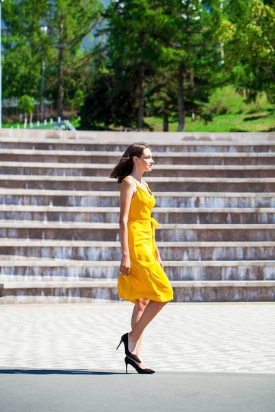 フルボディポートレートの若いです美しいですブルネット女性歩くと夏の通り — ストック写真