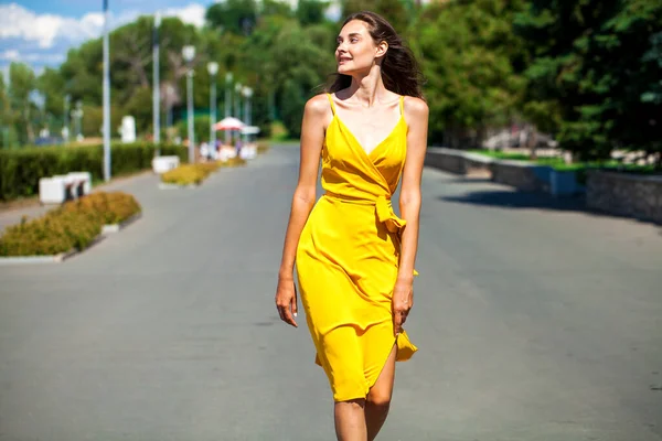 一位身穿黄色衣服的年轻金发女子在夏日公园散步时的近照 — 图库照片