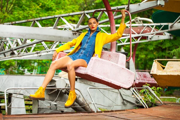 Parlak Sarı Montlu Güzel Bir Kız Lunaparktaki Bir Atlıkarıncada Oturuyor — Stok fotoğraf