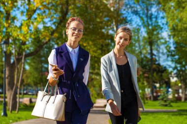 Yaz parkında yürüyen iki genç kız öğrenci.