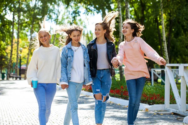 秋の公園を歩く4人の幸せな若い女の子 — ストック写真