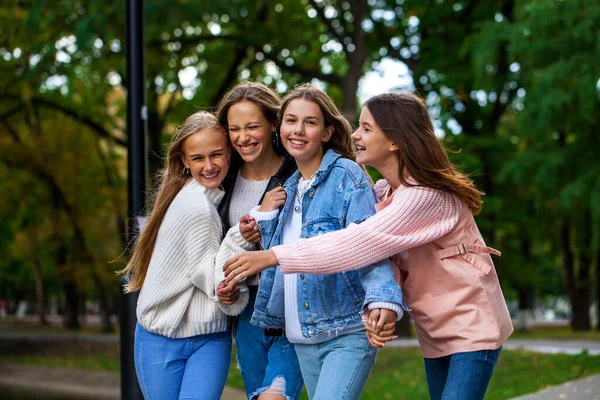 秋の公園を歩く4人の幸せなティーンの女の子 — ストック写真