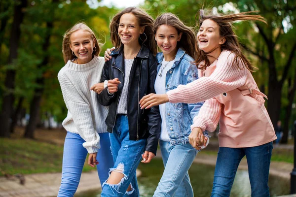 秋の公園を歩く4人の幸せなティーンの女の子 — ストック写真