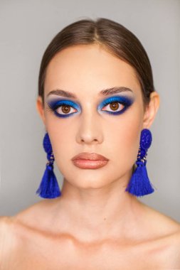 Güzellik uydur. Gri arka planda izole edilmiş güzel esmer model.