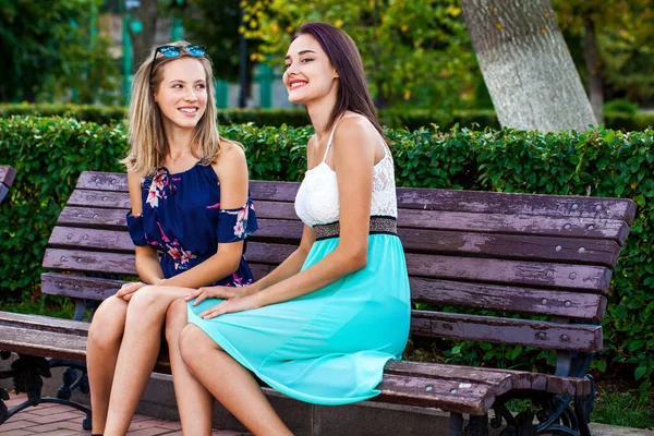Δύο Νεαρές Όμορφες Κοπέλες Κάθονται Ένα Παγκάκι Ένα Καλοκαιρινό Πάρκο — Φωτογραφία Αρχείου