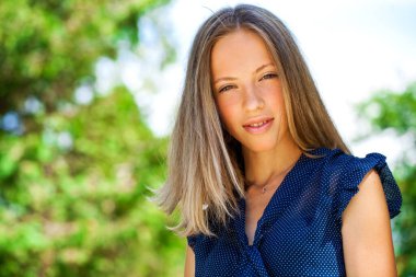 Yaz parkında genç ve güzel sarışın bir kadının portresi.