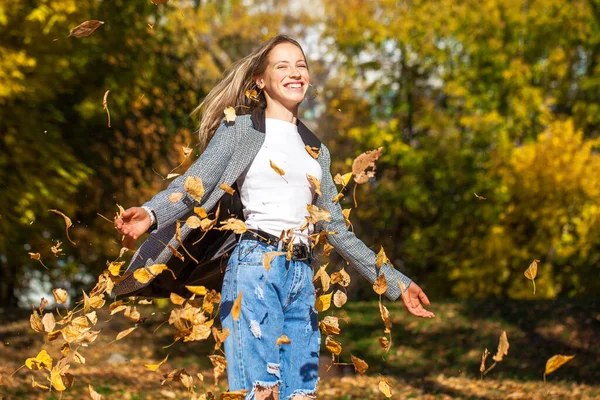 秋の公園でポーズをとっているスタイリッシュなフリップジーンズの若い美少女の肖像画 — ストック写真