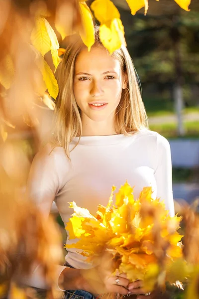 年轻美丽的金发姑娘被秋叶包围的户外时尚照片 — 图库照片