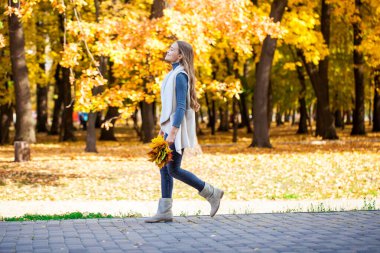 Güz parkında poz veren güzel genç kız.